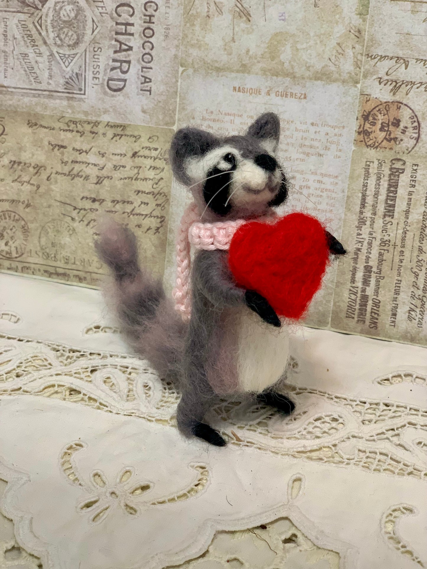 Stuffed animal holding a red heart on a textured surface with vintage text.