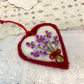 Heart-shaped felt ornament with floral design on a lace background