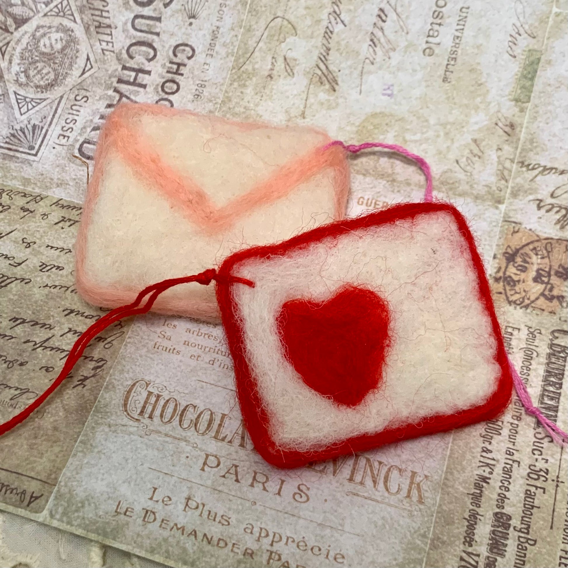 Red heart-shaped pouch with a pink heart on a textured paper background