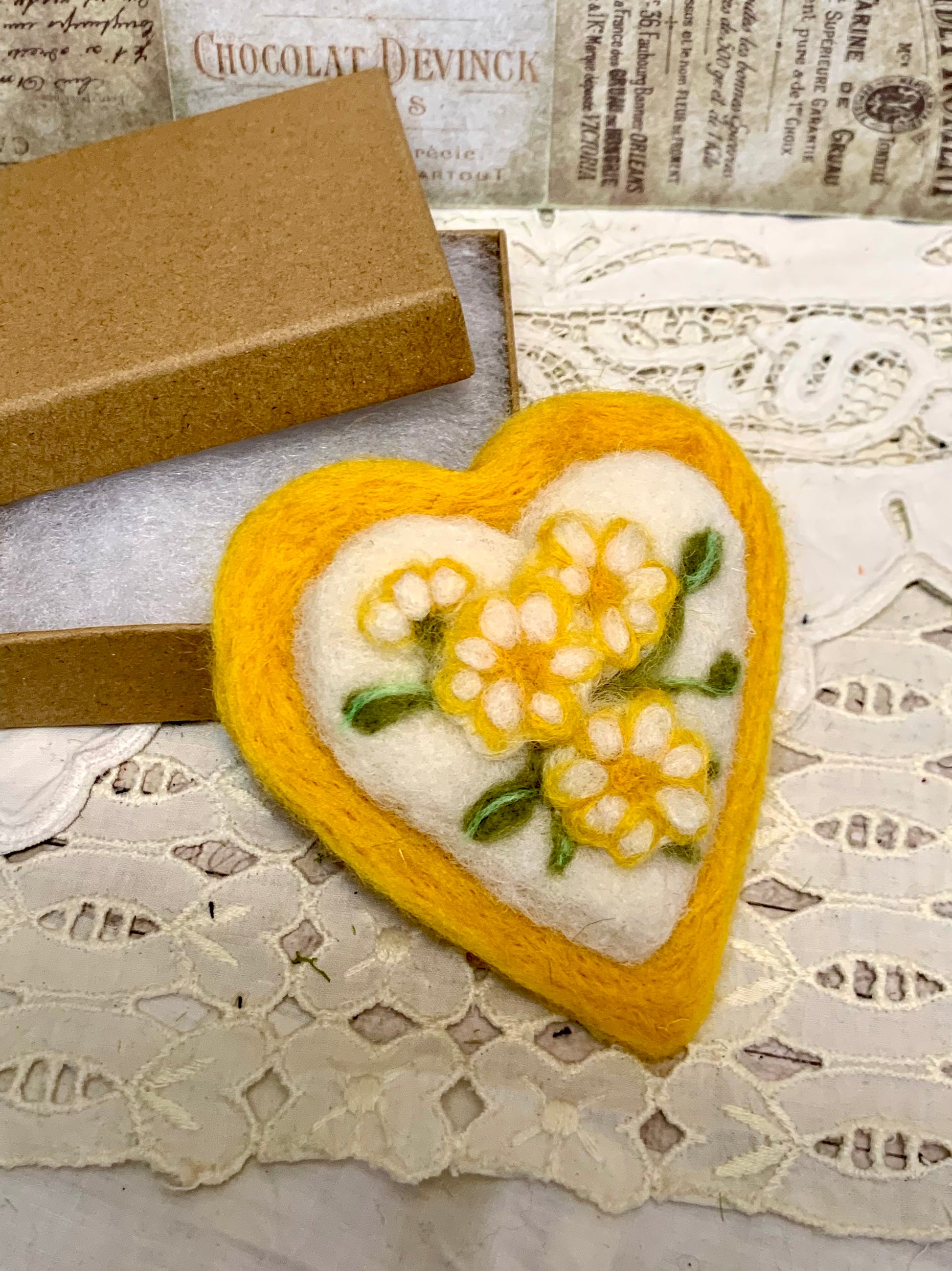 Heart-shaped embroidered patch with yellow flowers on a lace background