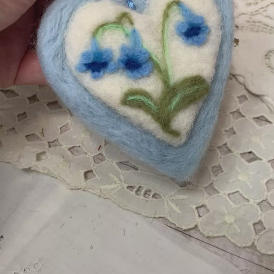 This handmade needle-felted heart is delicately embroidered with a bluebell flower, a timeless symbol of gratitude, humility, and quiet devotion.
